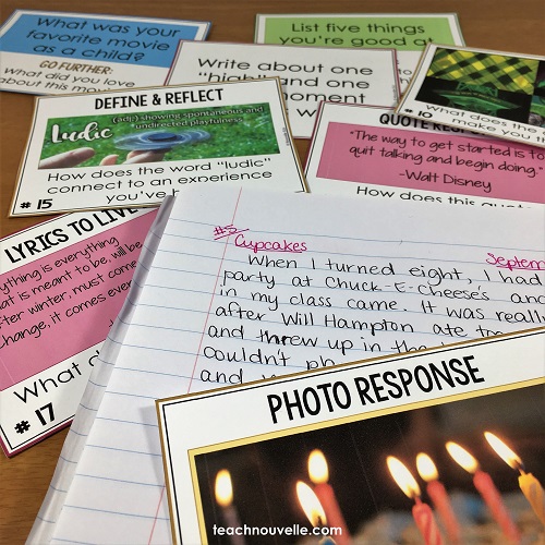 An open notebook is surrounded by writing prompts on flash cards.